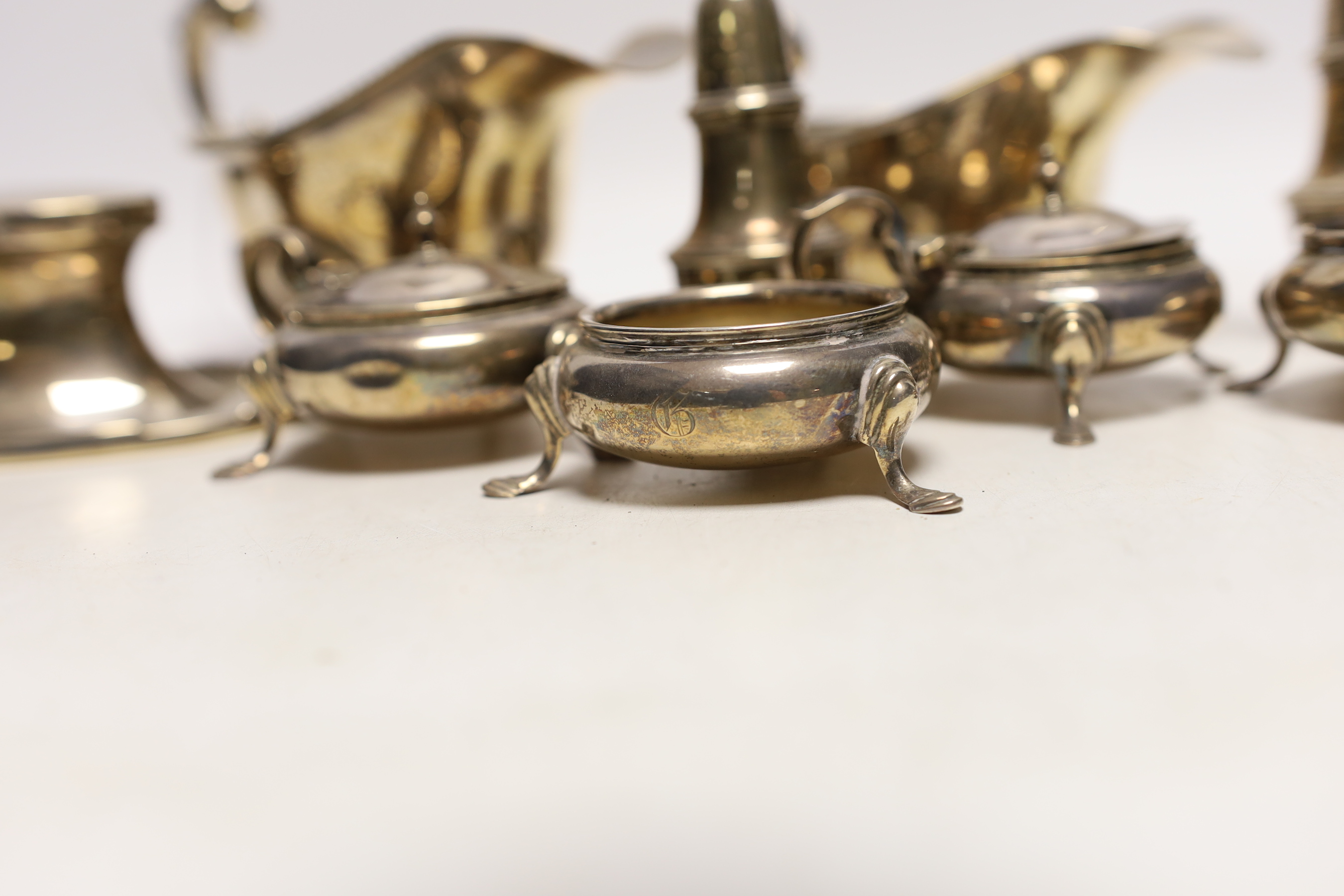 A small selection of silver items to include two sauceboats, a pair of cauldron salts, a further pair of lidded cauldron salts, together with a pair of pots and an inkwell.